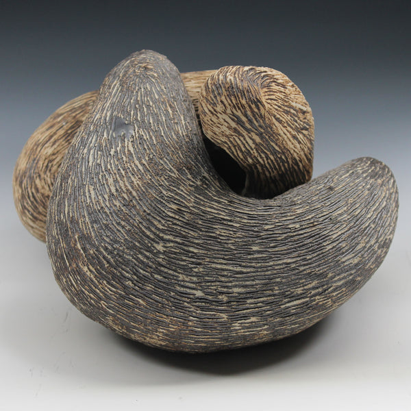 Two interrelated organic forms reminiscent of otters nestled together in a hug. Both can be used as vessels and alternate formations can be arranged by home owner.