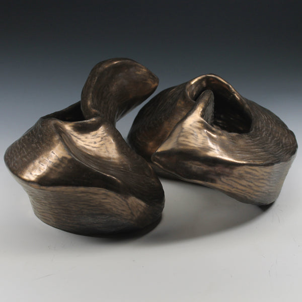 Gold glazed ceramic sculpture with two nestled organic forms with openings