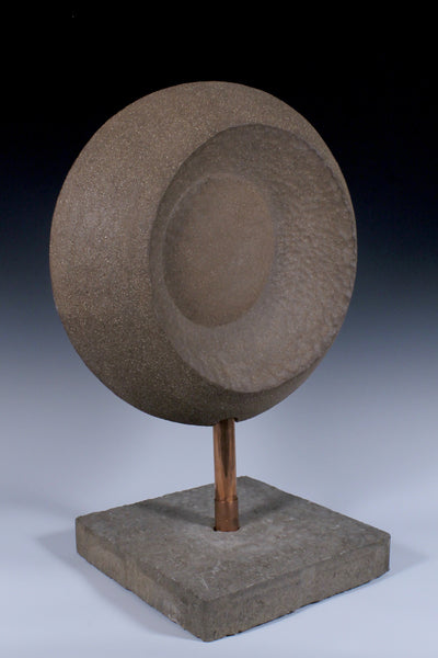 Back view of Large circular ceramic sculpture with convex and concave surfaces mounted on custom base with copper piping through a concrete base